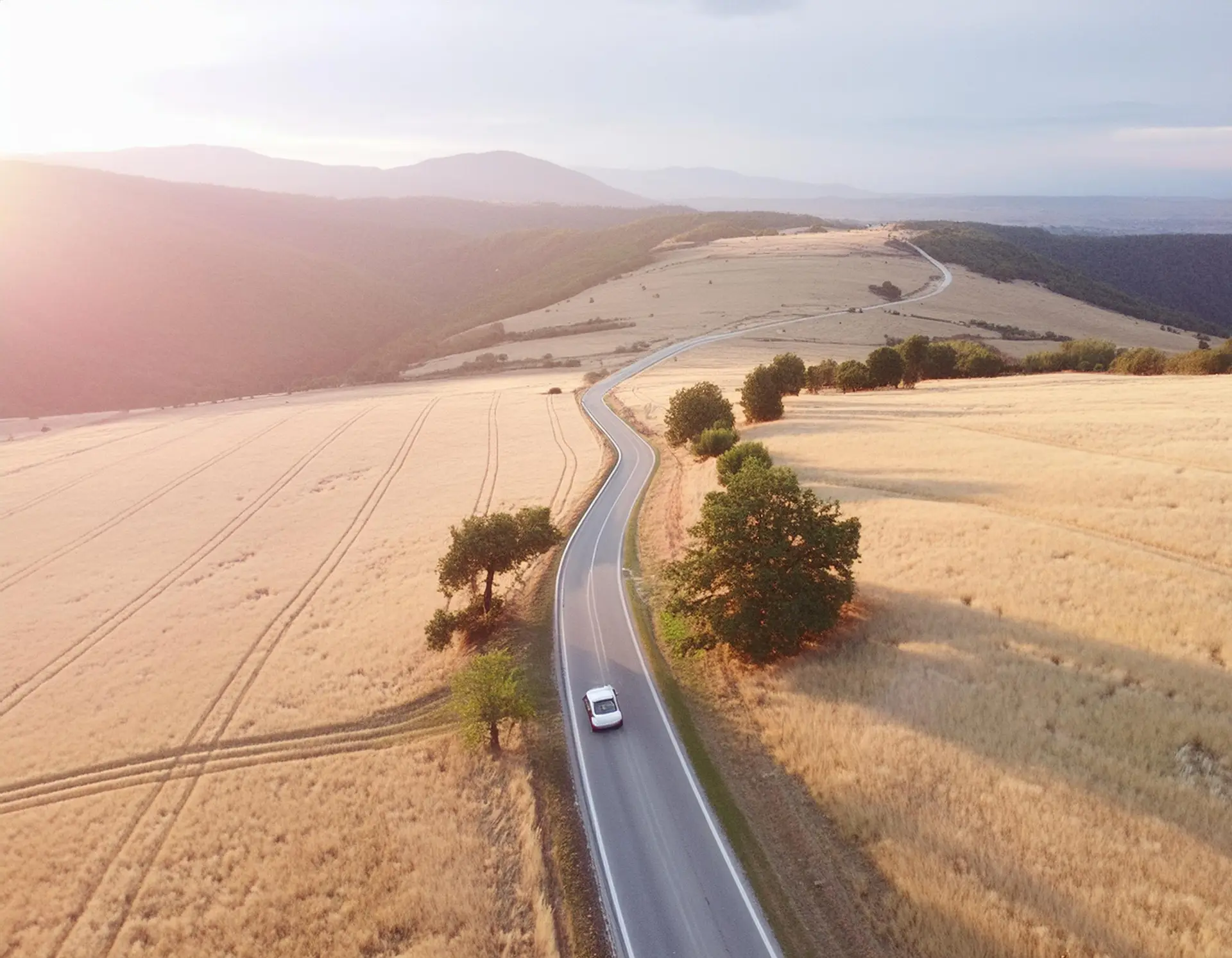 Firefly-Car-traveling-on-a-way-looking-from-above-to-golden-meadow-at-sunset-48947.jpg